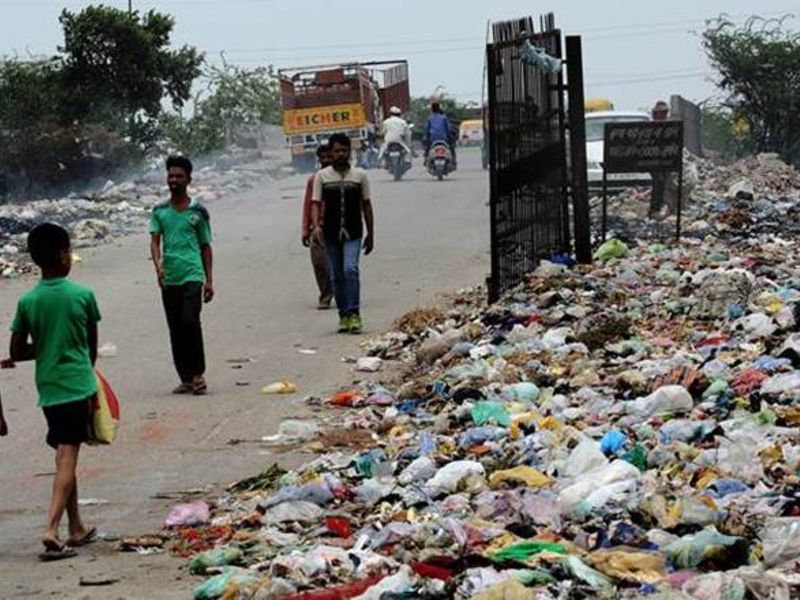 Children walk by the garbage dump site.